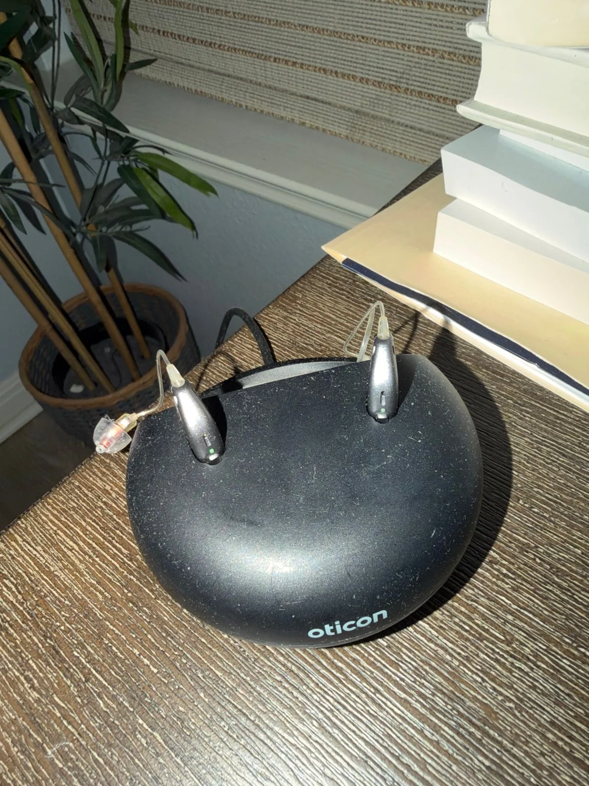 Oticon desktop charger with the More 1 hearing aid and CROS PX transmitter